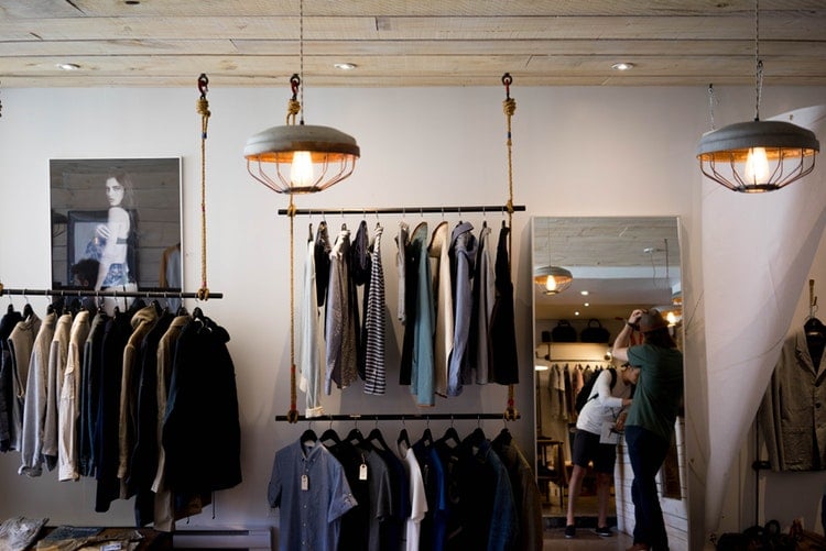 Agencement magasin - cabine d essayage - GMAO retail et magasins et boutiques - Bob! Desk, logiciel de gestion de maintenance - SAAS : portant de vêtements sur cintres dans une cabine d'essayage - luminaires, lumière tamisée